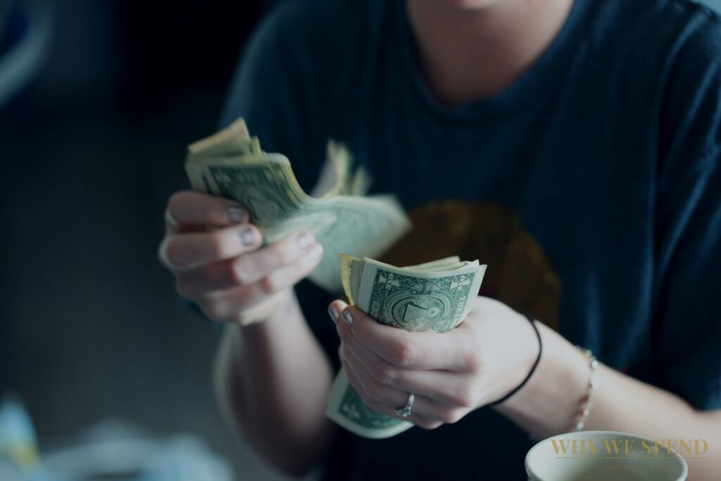 Person counting cash — payday spending spike psychology