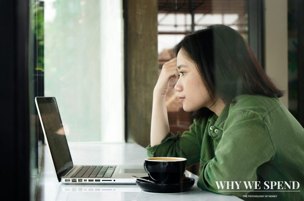 Person looking concerned while reading tech news on laptop, representing FOMO about corporate spending