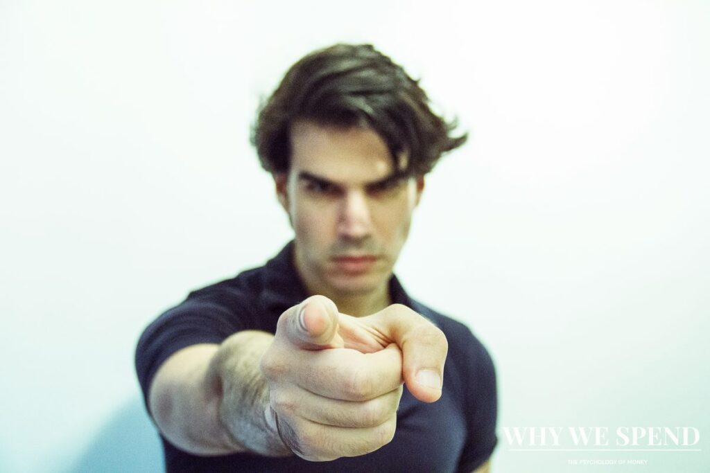 Man pointing directly at camera with an intense expression representing the pressure of financial judgement and social expectations