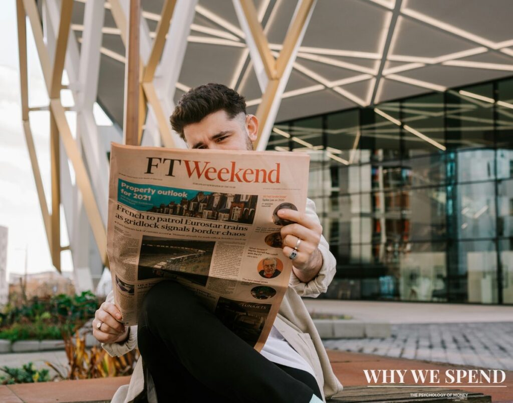 Person reading alarming financial headlines on newspaper looking stressed and worried