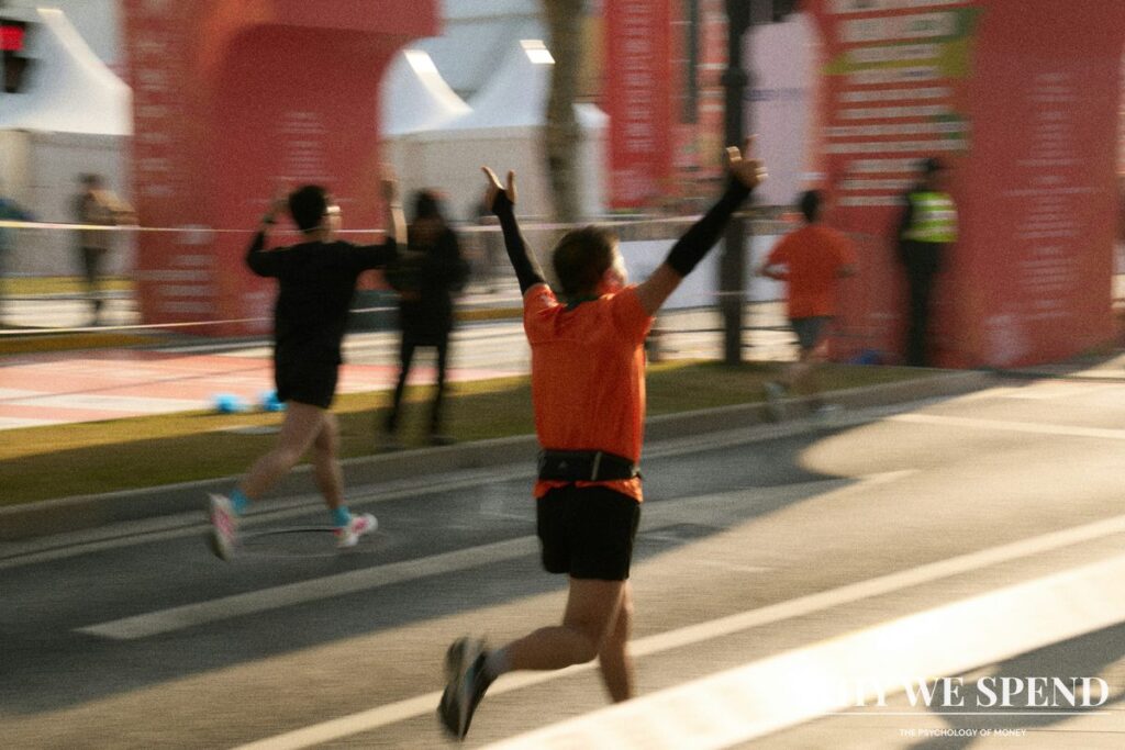 Runner approaching finish line with arms raised in premature celebration