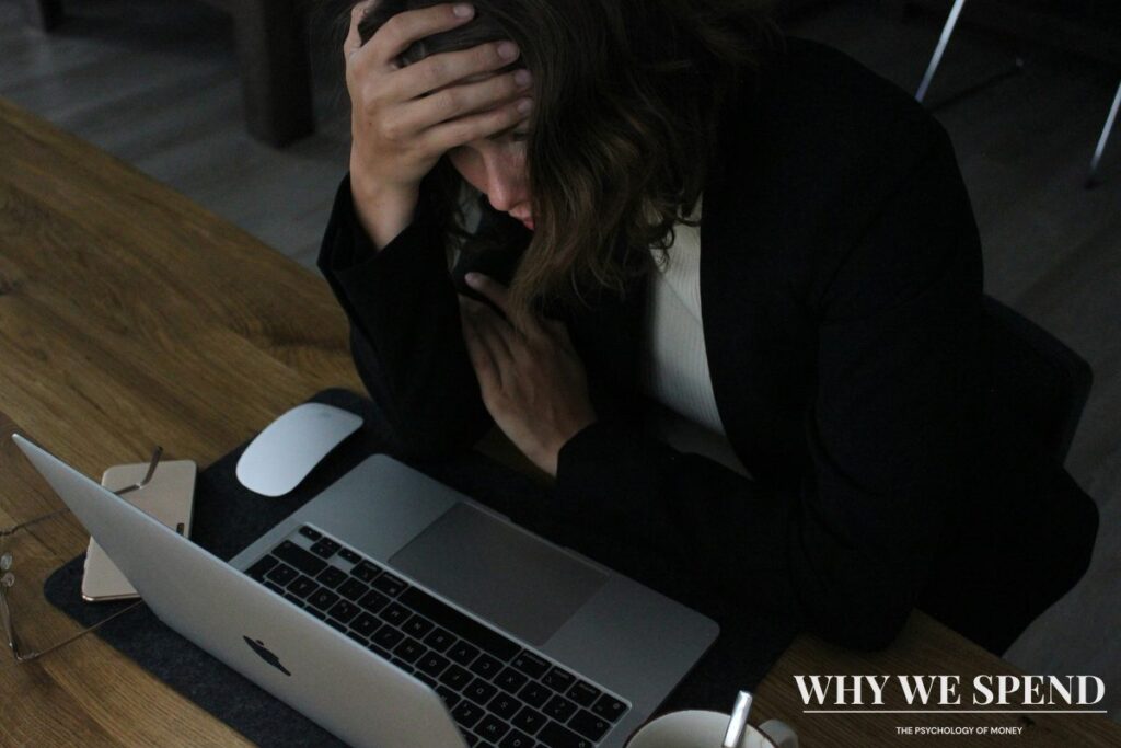 Person looking stressed while reviewing monthly bills and subscriptions on laptop
