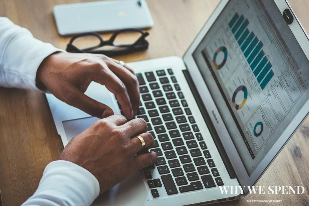 Person working on financial spreadsheet with colour-coded categories on laptop