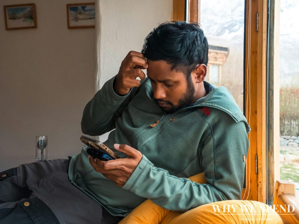 Person looking anxiously at mobile phone screen checking finances