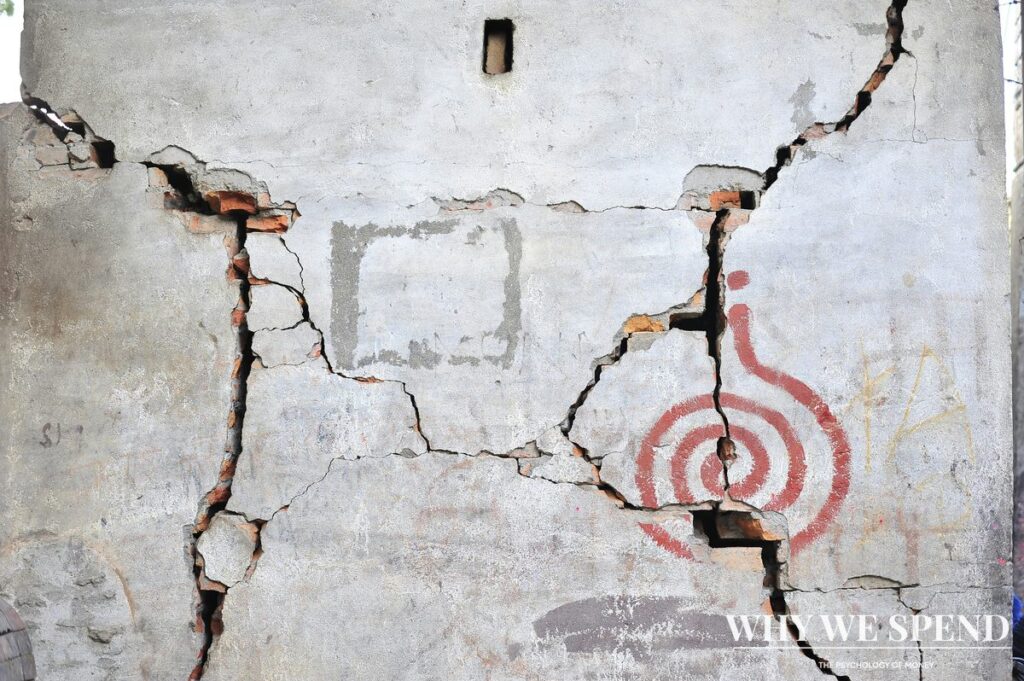 Cracked concrete wall showing structural damage representing ignored financial warning signs