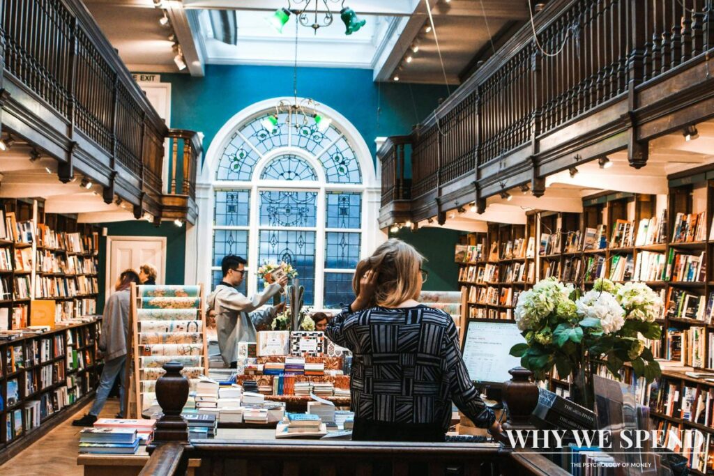 Person browsing physical books in bookstore with concerned expression