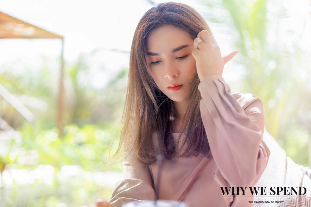 Asian woman looking stressed whilst reviewing financial documents