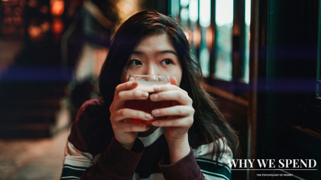 Young Asian woman in cafe looking thoughtful about spending decisions