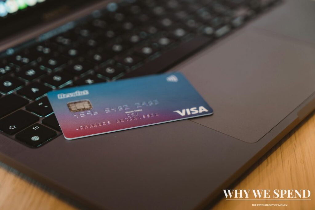 Multiple credit cards arranged with laptop showing online shopping cart