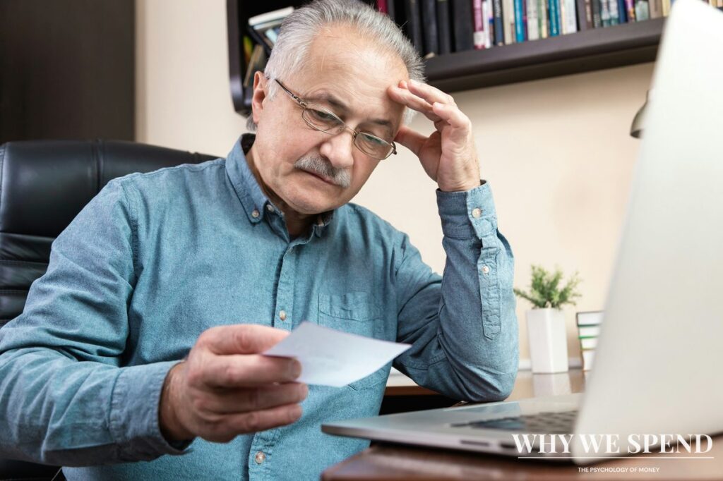 Person looking stressed while reviewing financial documents and bills