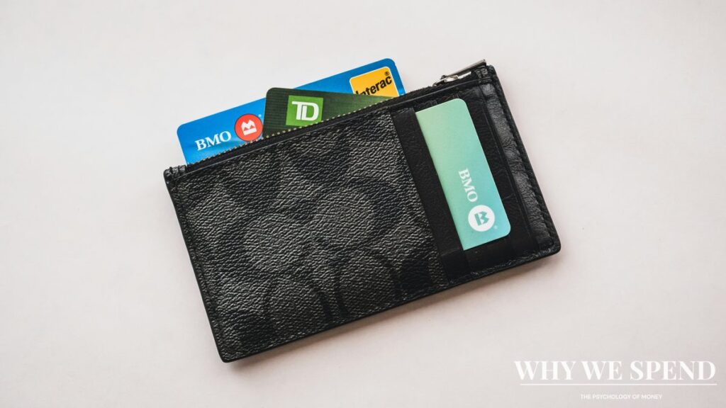 Empty wallet with multiple credit cards spread out on table
