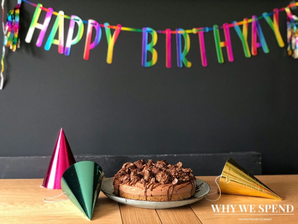 Birthday cake with candles and party decorations representing birthday spending habits
