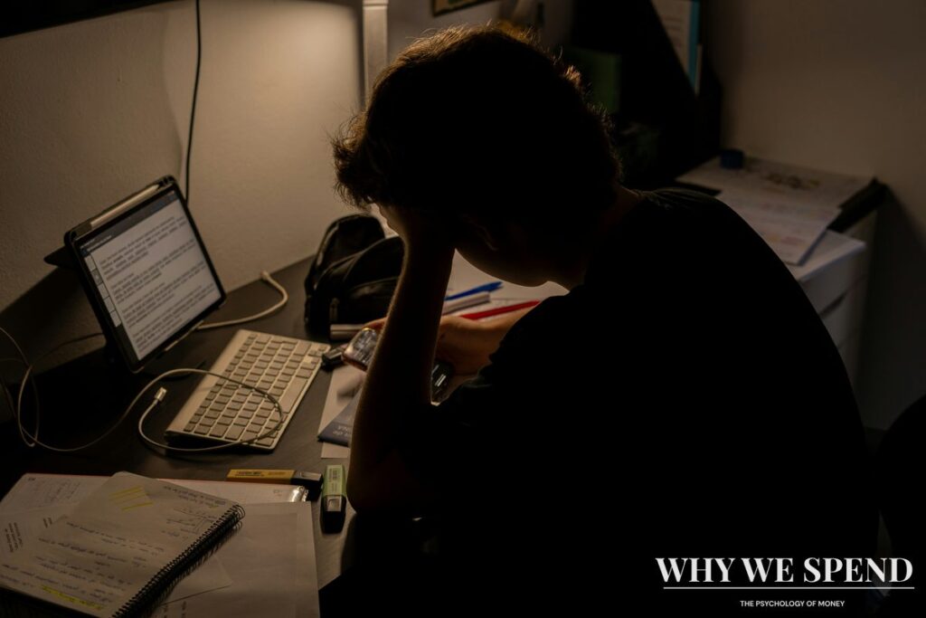 Person looking stressed while reviewing financial documents and bills at desk